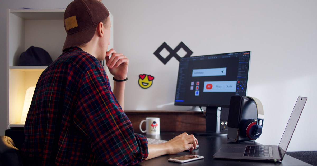 Web designer at a desk reviewing client feedback on a website